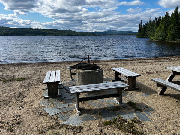 Eldstad med bänkar runt på stranden