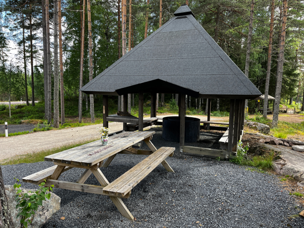 Bänkbord framför grillplatsen