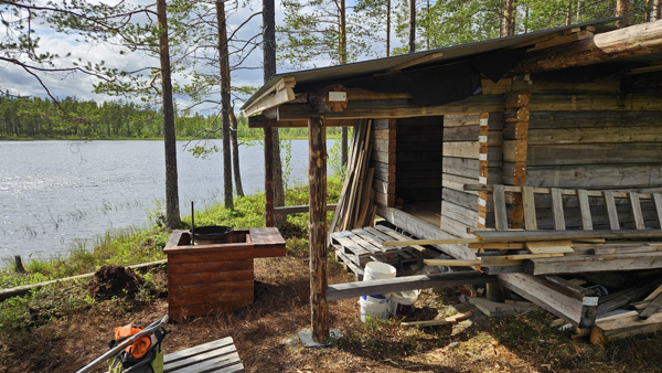 Grillplats framför kojan, ved finns. Fortfarande lite byggarbetsplats