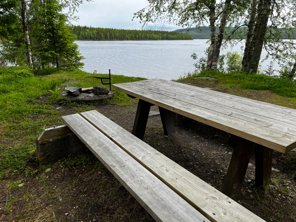Bänkbord med eldstad i bakgrunden