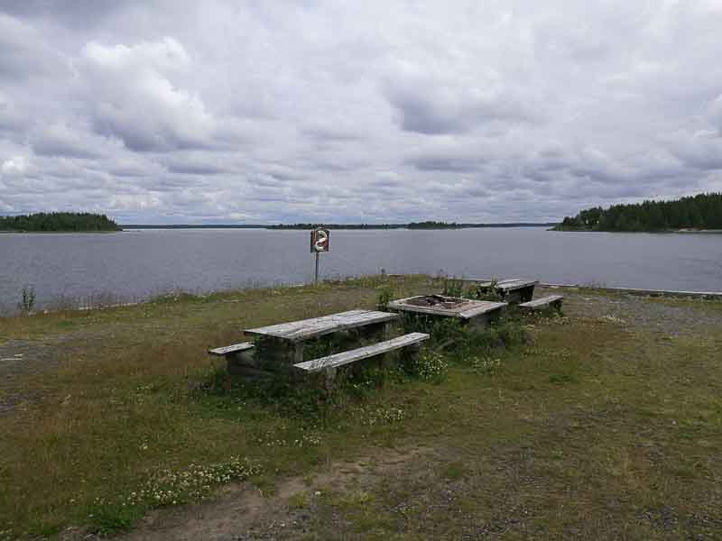 Två picknickbord på var sin sida om eldstaden. Allt ute på "piren"