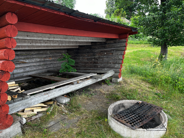 Insidan av vindskyddet och eldstaden framför